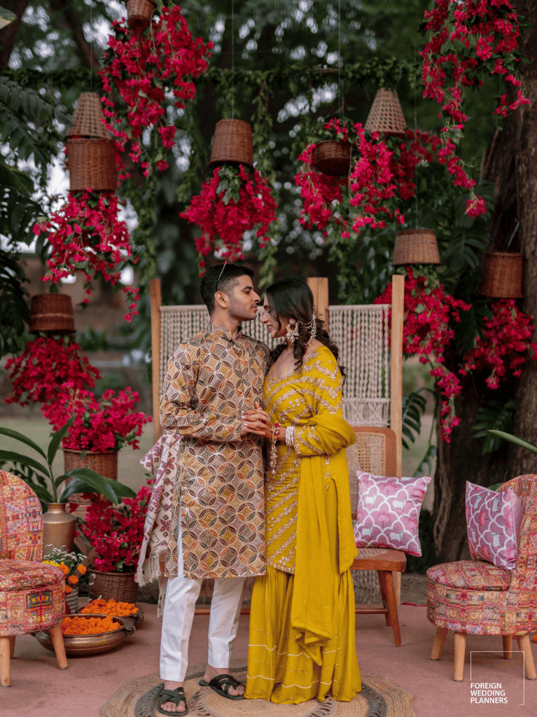 a man and woman kissing under baskets of flowers
Indian Wedding Guide 2025: Its all about personalisation, sustainability, and cutting-edge innovation. Image courtesy: Foreign Wedding Planners
