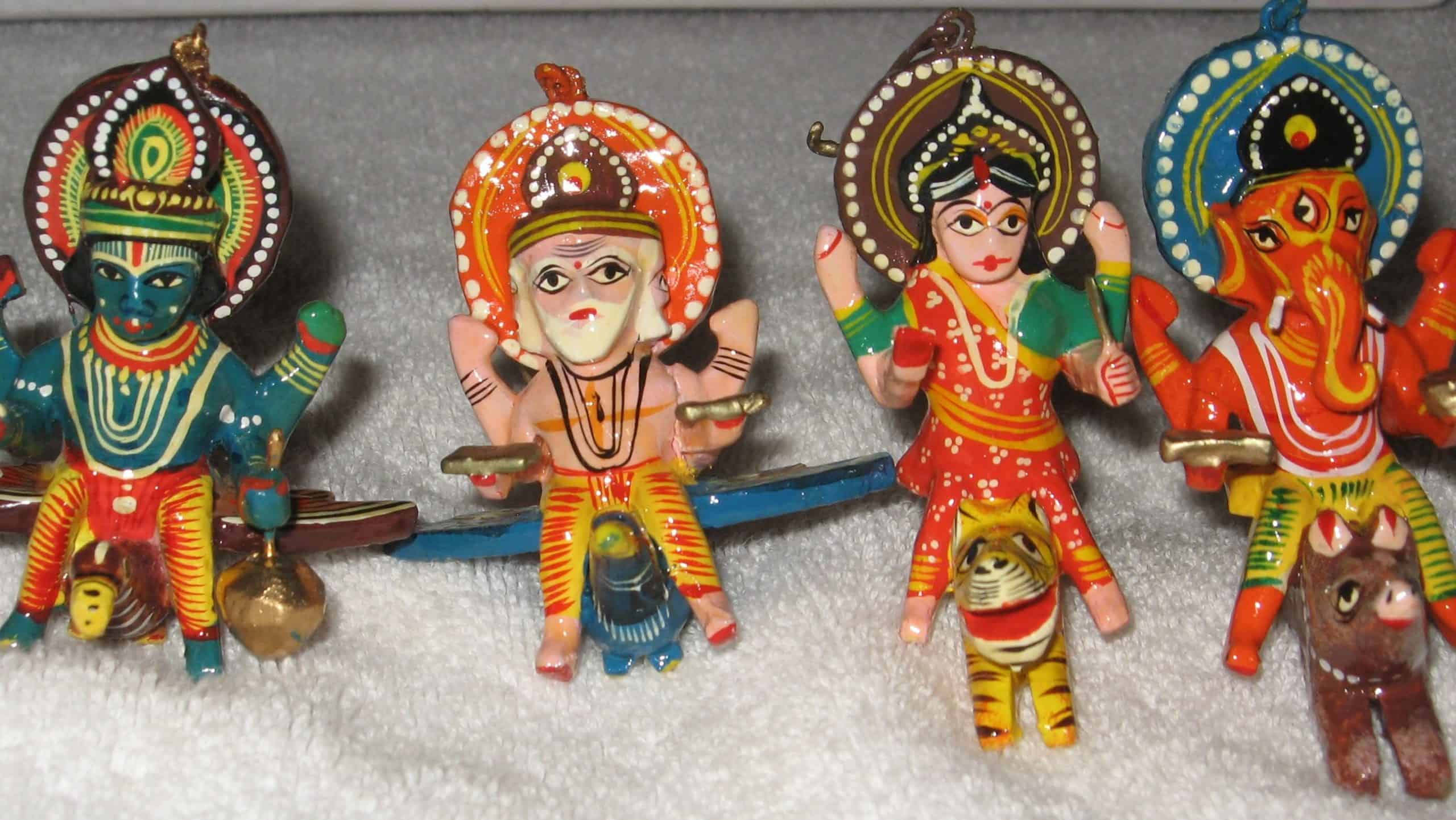 Intricately hand-painted wooden idols of Hindu deities, showcasing the vibrant folk art of Indian craftsmanship and devotion. Courtesy: The Cultural Heritage of India 