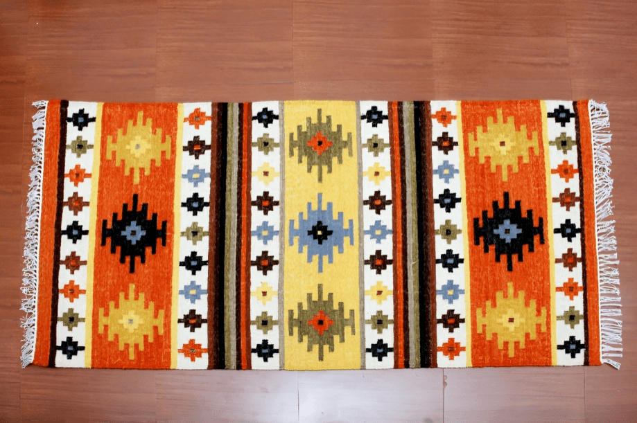 Vibrant handwoven dhurries drying in the sun, a living tapestry of India’s rural artistry and cultural heritage. Courtesy: indiahandmade.com