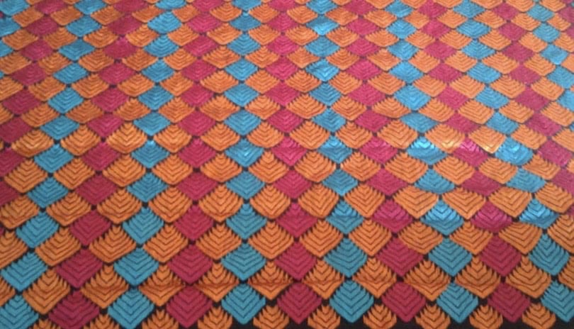 The craft of Phulkari was worked on khaddar, a coarse, handspun cotton base, with untwisted silk threads known as pat. Image courtesy Sheebamadanloewinger via Wikimedia Commons